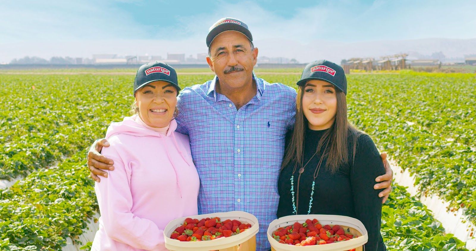 the contreras family standing in a strawberry field